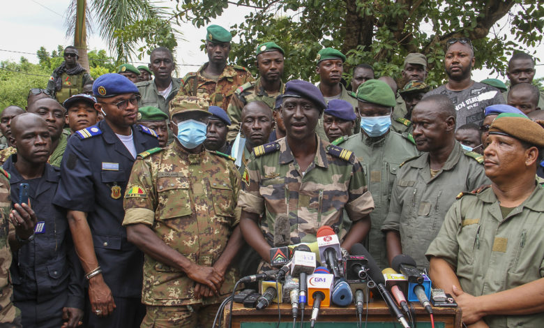 Colonel-Major Ismael Wague, centre, spokesman for the soldiers identifying themselves as National Committee for the Salvation of the People, speaks during a press conference at Camp Soudiata in Kati, Mali, Wednesday, Aug. 19, 2020, one day after President Ibrahim Boubacar Keita was forced to resign in a military coup. The military takeover was swiftly condemned by the international community, despite promesses of new elections. (AP Photo/Arouna Sissoko)